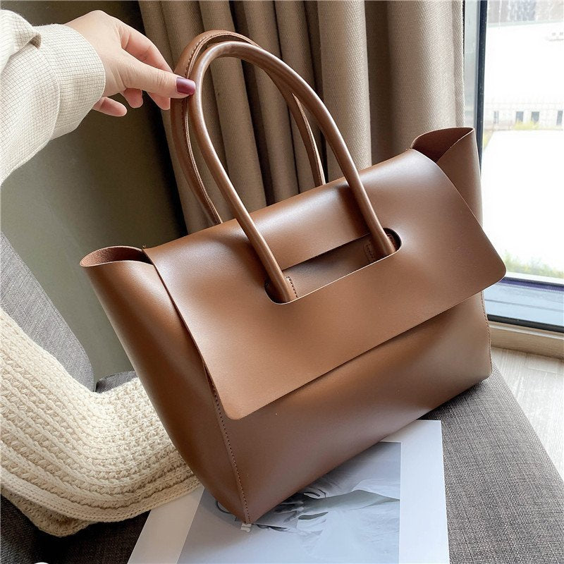 Brown Structured Flap Tote held by the handles