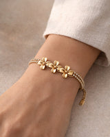 Gold-tone flower bracelet worn on the wrist