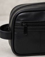 Close-up detail of the black faux leather dopp kit