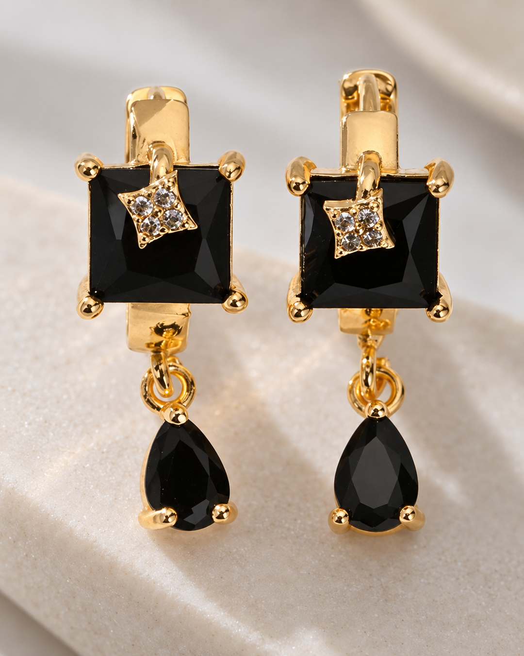Close-up detail of the black square drop earrings