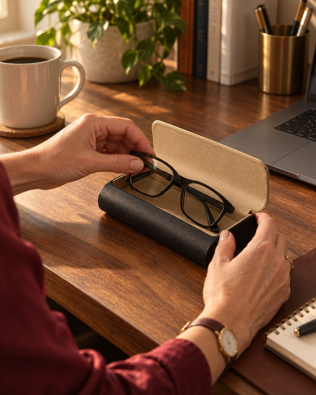 Two-tone glasses case open with reading glasses on a home office desk
