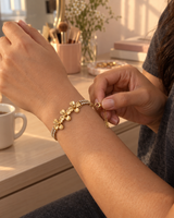 Gold-tone flower bracelet being fastened on the wrist