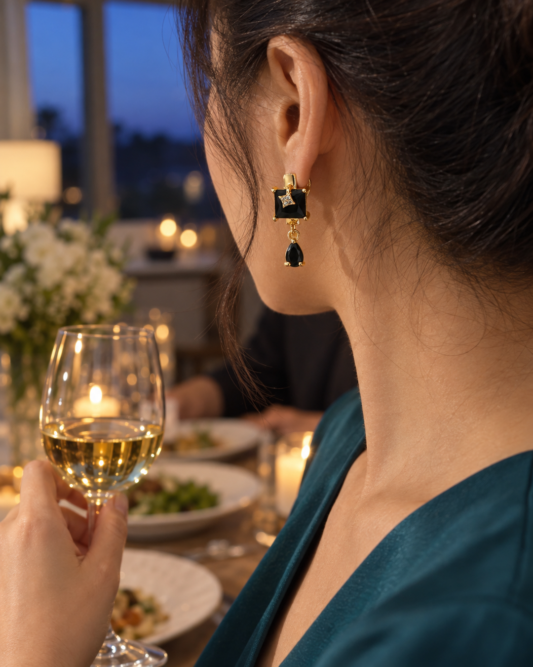 Black square drop earrings worn at a dinner party, rear view