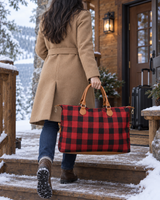 Red buffalo check weekender bag carried to a cabin in the snow