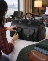 Black folding weekender bag opened on a hotel bed