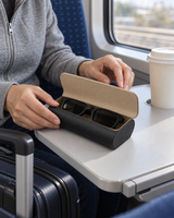 Two-tone glasses case closed with sunglasses on a train