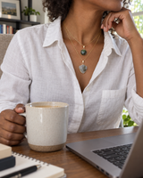 Layered stone pendant necklace worn at a home office desk