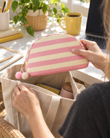 Pink striped canvas pouch pulled from a tote bag at an office desk