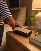 Two-tone glasses case on a nightstand next to a book