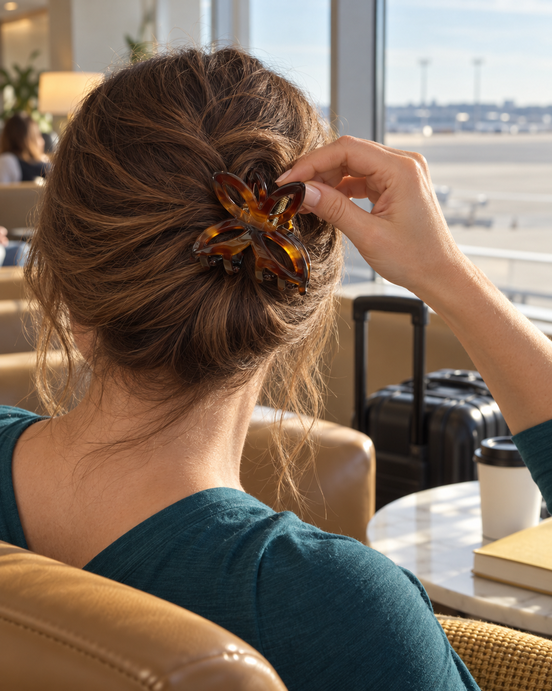 Tortoiseshell butterfly hair claw clipped into hair in an airport lounge