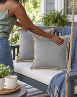 Gray linen pillow covers with jute trim on a porch swing in summer