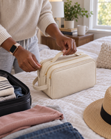 Hanging toiletry bag zipped closed on a bed the night before a trip